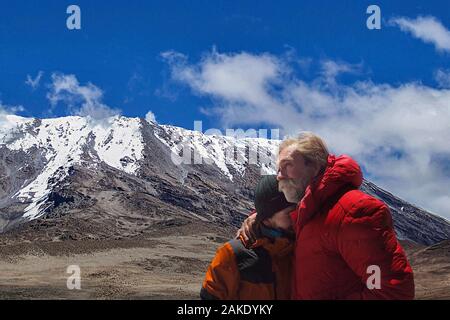 HANDOUT - 12. August 2018, Tansania, Kilimandscharo: Der Hamburger Abenteurer Achill Moser (r) umarmt seinen Sohn Aaron am Kilimanjaro. Achill Moser, Hamburg travel Journalist und Abenteurer, hat einen bestimmten Berg nach 28 Wüste Wanderungen genannt. Zusammen mit seinem Sohn Aaron, bestieg er den höchsten Berg in Afrika auf fast 6000 Meter. Das Abenteuer wurde in einem Dokumentarfilm und in einem Reiseführer aufgezeichnet. (Dpa' eine Hamburg Generation Reunion am Kilimanjaro") Foto: Aaron und Achill Moser/Aaron und Achill Moser/dpa - ACHTUNG: Nur für die redaktionelle Verwendung im Zusammenhang mit der aktuellen Berichterstattung und nur mit Stockfoto