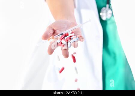 Doktor, der verschiedene Pillen und Kapseln von Hand fallen lässt Stockfoto