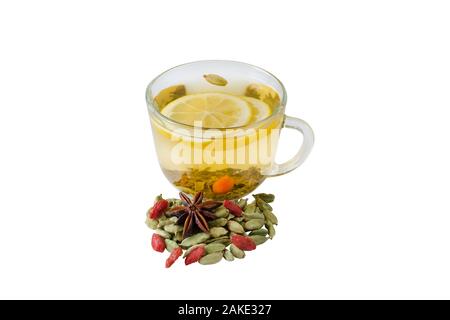 Ein Glas Tee mit Zitrone, Goji, Kardamom und Nelken auf weißem Hintergrund Stockfoto