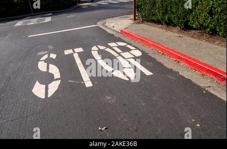 Stop-Schild auf dem Asphalt der Roten bändigen Straße an der Kreuzung lackiert Stockfoto