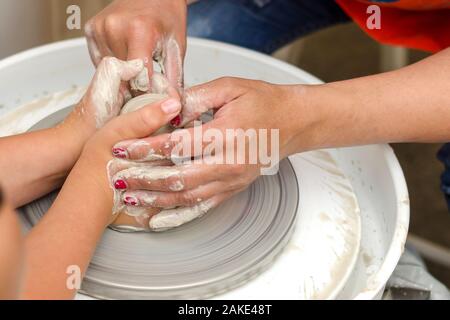 Eine Nahaufnahme der Kind lernt den Ton zu kneten. Stockfoto