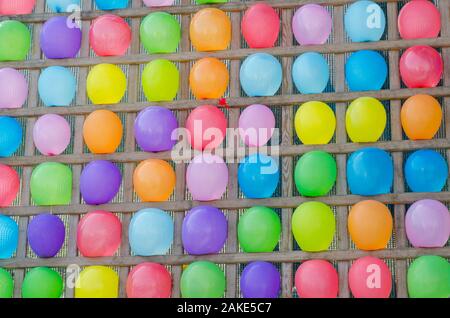 Holz Ständer mit Seil und bunten Luftballons. Farbenfrohe bunte Ballon abstrakt Hintergrund. Unterhaltung werfen Abnäher Ballons Stockfoto