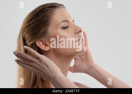 Waschen Sie Ihr Gesicht, und achten Sie auf Ihre Haut. Porträt einer jungen Frau mit schöner, klarer Haut, Nahaufnahme auf weißem Hintergrund. Hautpflege, Reinigung. Stockfoto