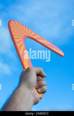 Boomerang vor einem blauen Himmel in Hand Stockfoto