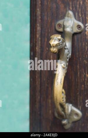 Altes Messing auf vintage Holz Türgriff in Form von Panther. Stockfoto