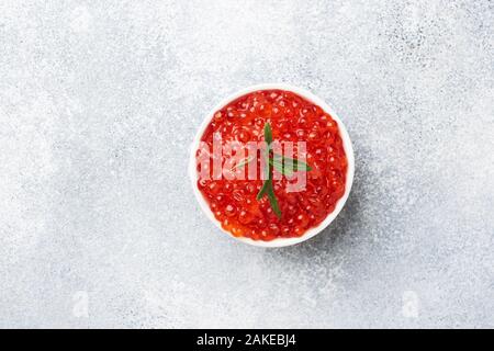 Roter Lachskaviar in eine Platte auf grauem Beton Hintergrund. Snack Delikatesse. Platz kopieren Stockfoto