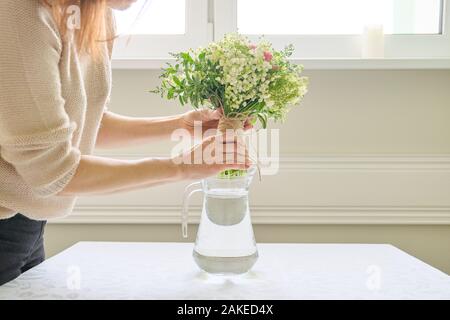 Strauß mit frischen Blumen, Frau, Hände, die Bouquet, Platzierung in der Vase auf dem Tisch Stockfoto