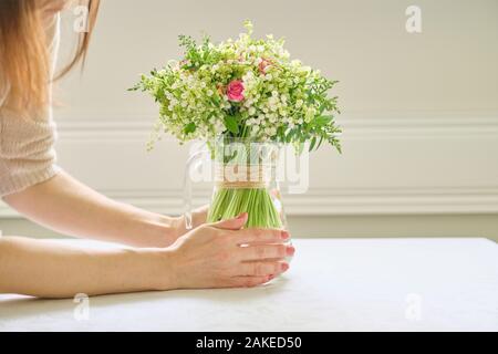 Strauß mit frischen Blumen, Frau, Hände, die Bouquet, Platzierung in der Vase auf dem Tisch Stockfoto