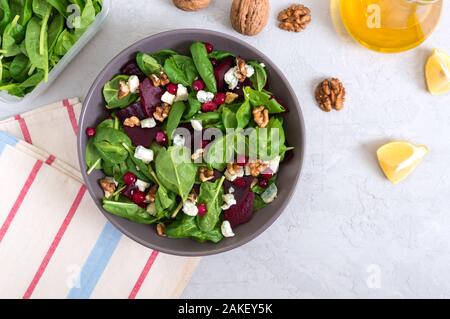 Salat mit junger Spinat, gekochte rote Rüben, Blau Käse, Nüsse, Cranberries in einer Schüssel auf einem hellen Hintergrund. Schmackhafte Diät Fitness Teller. Vitamin-Salat. Die ordnungsgemäße Stockfoto