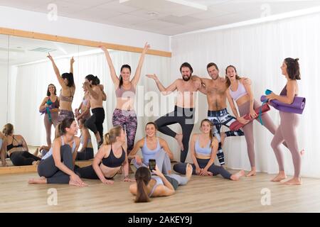 Gruppe von Jugendlichen authentisch echten sportlich attraktive Menschen in Yoga Studio Spaß Geselligkeit nach Hot Yoga Klasse. Gesunde, aktive Stockfoto