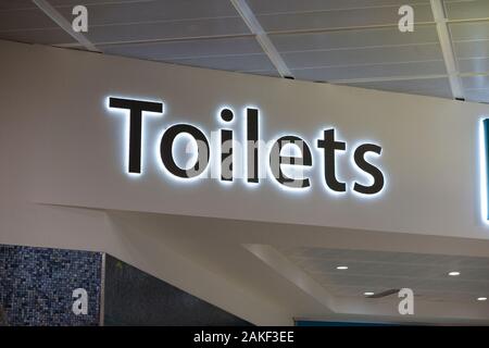 Schild/Beschilderung für öffentliche toiletten/Toiletten/Toilette/Toiletten, im Gepäckabgabebereich auf der Flugseite am Flughafen Gatwick, North Terminal. GROSSBRITANNIEN. (115) Stockfoto