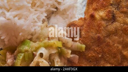Gebratenes Schweinefleisch Schnitzel mit Reis und Lauch Gemüse in Sahnesauce, Deutsches Essen Stockfoto
