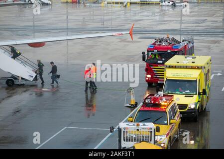 Rettungskräfte, Sanitäter, Rettungswagen Sanitäter nehmen an einem Flugzeug/Flugzeug/Flugzeug, nachdem ein Passagier während eines Rückflugs zum Flughafen krank geworden ist/krank geworden ist. England Großbritannien (115) Stockfoto