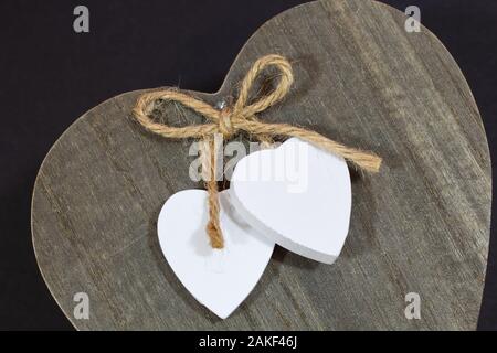 Loop aus Sisal mit 2 Herzen am Ende auf hölzernen Deckel Stockfoto