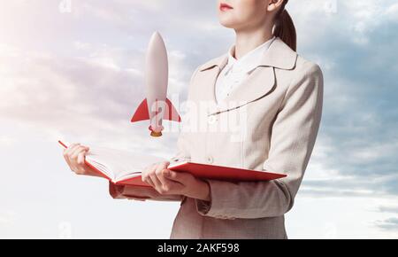 Frau, Rakete auf Buch öffnen Stockfoto