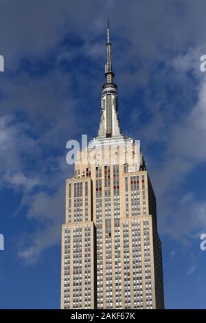 Das Empire State Building vor einem blauen teilweise bewölktem Himmel in New York, NY, USA Stockfoto