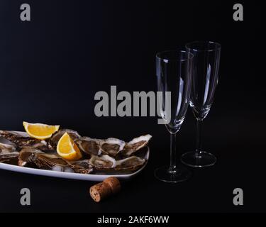 Frische Austern mit Zitrone und Champagner serviert werden. Öffnen Sie Austern auf Eis. Stockfoto