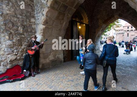 Ein als Cowboy gekleideter Buscher, der unter dem Torbogen in der Altstadt von Krakow, Polen, Land- und Westernlieder singt Stockfoto