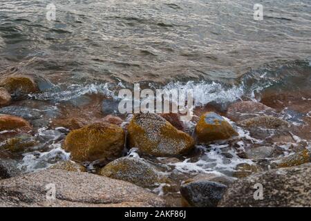 Die Steine am Meer Strand. Weide winter Tag. Klares Wasser und Sand. Stockfoto