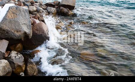 Die Steine am Meer Strand. Weide winter Tag. Klares Wasser und Sand. Stockfoto