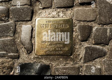 BERLIN, DEUTSCHLAND - 24. MAI 2018: ein Stolperstein, einen goldenen Würfel mit den Namen und die Lebensdaten der Opfer nationalsozialistischer Vernichtungslager, in dem Gehsteig der eine Str Stockfoto