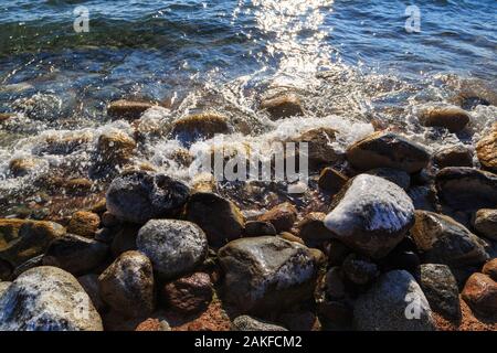 Die Steine am Meer Strand. Weide winter Tag. Klares Wasser und Sand. Stockfoto