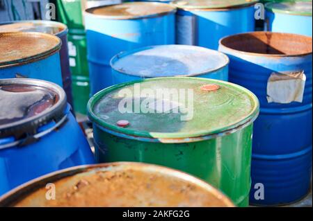 Recyclingindustrie - rostige Metallfässer in Reihen, giftiger Abfall. Stockfoto