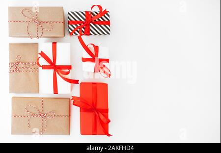 Sammlung von Weihnachtsgeschenk Boxen auf einem weißen Hintergrund. Geschenkbox aus recyceltem Papier mit Schleife umwickelt. Flach Stockfoto