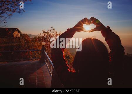 Ein Thai Girl, Herz und ihre Hände über ihren Kopf bei Sonnenaufgang Stockfoto