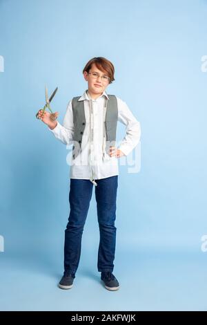 Kleinen Jungen träumen von zukünftigen Beruf der Näherin. Kindheit, Bildung und Traum Konzept. Will erfolgreicher Mitarbeiter in Fashion und Style Industrie zu werden, Atelier, macht Kleidung. Copyspace. Stockfoto