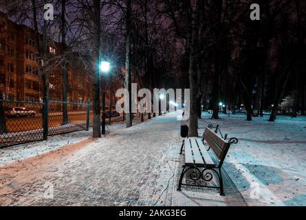 Nacht Park im Winter mit Bäumen, Laternen, Bank, auf Vorder- und Gefallener Schnee. Landschaft. Stockfoto