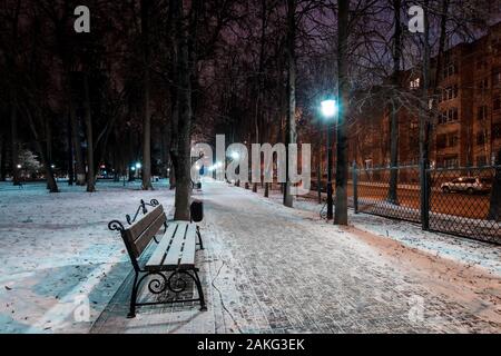 Nacht Park im Winter mit Bäumen, Laternen, Bank, auf Vorder- und Gefallener Schnee. Landschaft. Stockfoto