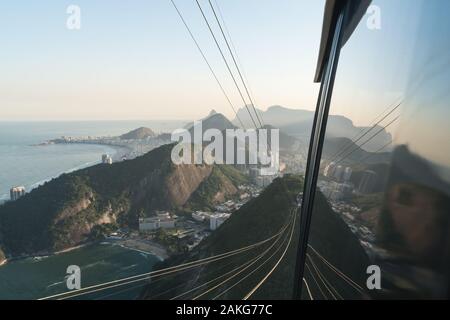 Die Luftaufnahme vom Zuckerhut in Rio de Janeiro, spiegelt sich in dem Fenster der Seilbahn. Stockfoto