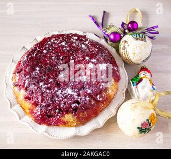 Ganze runde Cranberry tart Torte Kuchen auf weiße Platte auf hölzernen Tisch Hintergrund mit Weihnachten Neujahr Dekoration Nähe zu sehen. Selektive konzentrieren. Chris Stockfoto