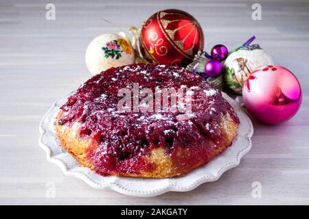 Ganze runde Cranberry tart Torte Kuchen auf weiße Platte auf hölzernen Tisch Hintergrund mit Weihnachten Neujahr Dekoration Nähe zu sehen. Selektive konzentrieren. Chris Stockfoto