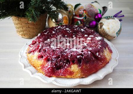 Ganze runde Cranberry tart Torte Kuchen auf weiße Platte auf hölzernen Tisch Hintergrund mit Weihnachten Neujahr Dekoration Nähe zu sehen. Selektive konzentrieren. Chris Stockfoto