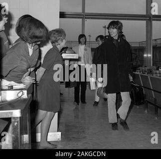 Die Beatles stars John Lennon (l) und George Harrison am Flughafen Heathrow, London, vor dem Fliegen nach Indien. Stockfoto