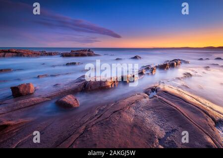 Frankreich, Var, Saint-Raphaël, Sonnenuntergang leuchten auf den Felsen von Péguière Strand mit dem Massif des Maures im Hintergrund Stockfoto