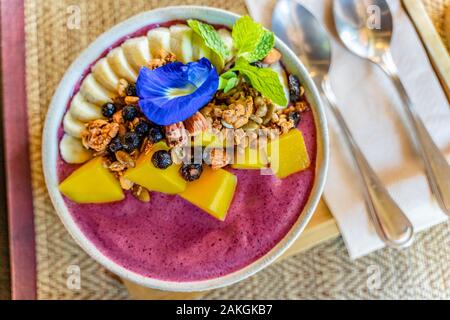 Mixed berry Joghurt Schüssel, gesundes Frühstück, mit Mango, Banane, und hausgemachtem Müsli, gutes gesundes Frühstück für gesunden Lebensstil Stockfoto