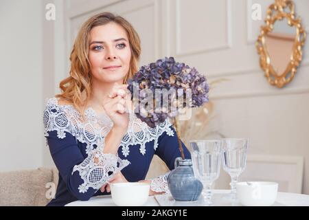Allein Denken junge Frau mit langen, lockigen Haar sitzt im Cafe. Stockfoto