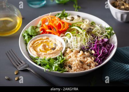 Veggie couscous Mittagessen Schüssel mit spiralazed Karotten und Zucchini, Hummus und Rotkohl Stockfoto