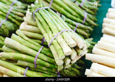 Trauben von frischen, rohen grünen Bio Spargel Gemüse zum Verkauf an Farmers Market. Veganes essen Konzept. Foto- und grünem Spargel. Raw Stockfoto