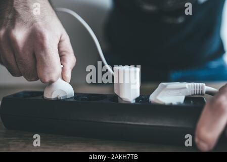 Nahaufnahme der Hand anschließen in die Steckdosenleiste an. Stockfoto