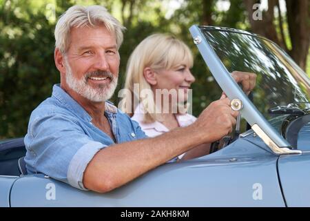 Reifes Paar Genießen Reise In der Klassischen offenen Sportwagen zusammen Stockfoto