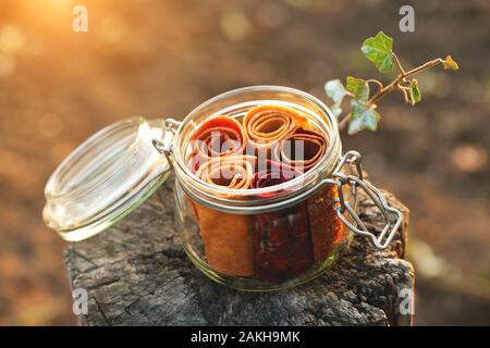 Glas Glas mit Obst pastille Roll-up auf einem natürlichen Hintergrund. Das Konzept der gesunde organische Süßigkeiten, richtige Ernährung, null Abfall, vegan. Stockfoto