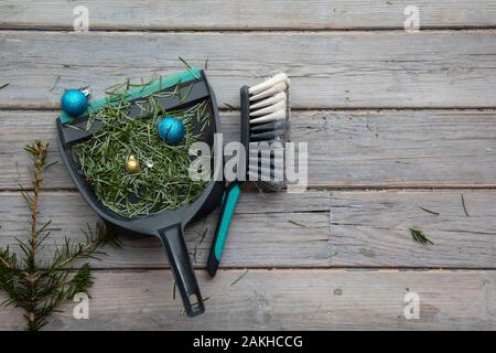 Reinigung bis nach Weihnachten. Fegen herauf Tannennadeln und kaputte Dekorationen Stockfoto