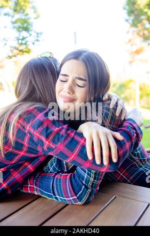 Blick auf zwei traurige beste weibliche Freunde einander umarmen Stockfoto