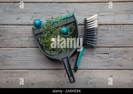 Reinigung bis nach Weihnachten. Fegen herauf Tannennadeln und kaputte Dekorationen Stockfoto