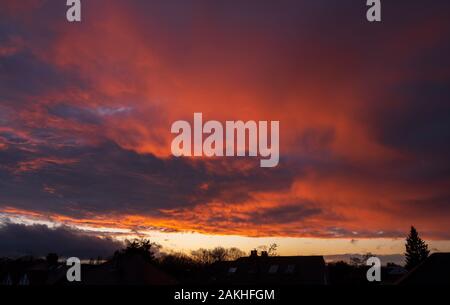 Wimbledon, London, UK. 9. Januar 2020. Clearing skies bei Sonnenuntergang nach schweren Nachmittag Regen, mit leuchtend bunte Sonnenlicht auf Wolken über die Dächer. Credit: Malcolm Park/Alamy Leben Nachrichten. Stockfoto