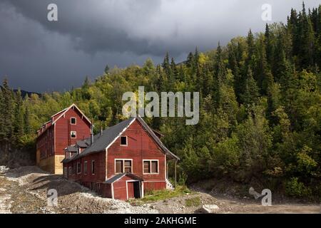 Zwei rote Holz- Cooper Mühle Gebäude umgeben von Nadelwald, Wrangell-St. Elias National Park, Kennecott, Alaska, USA Stockfoto